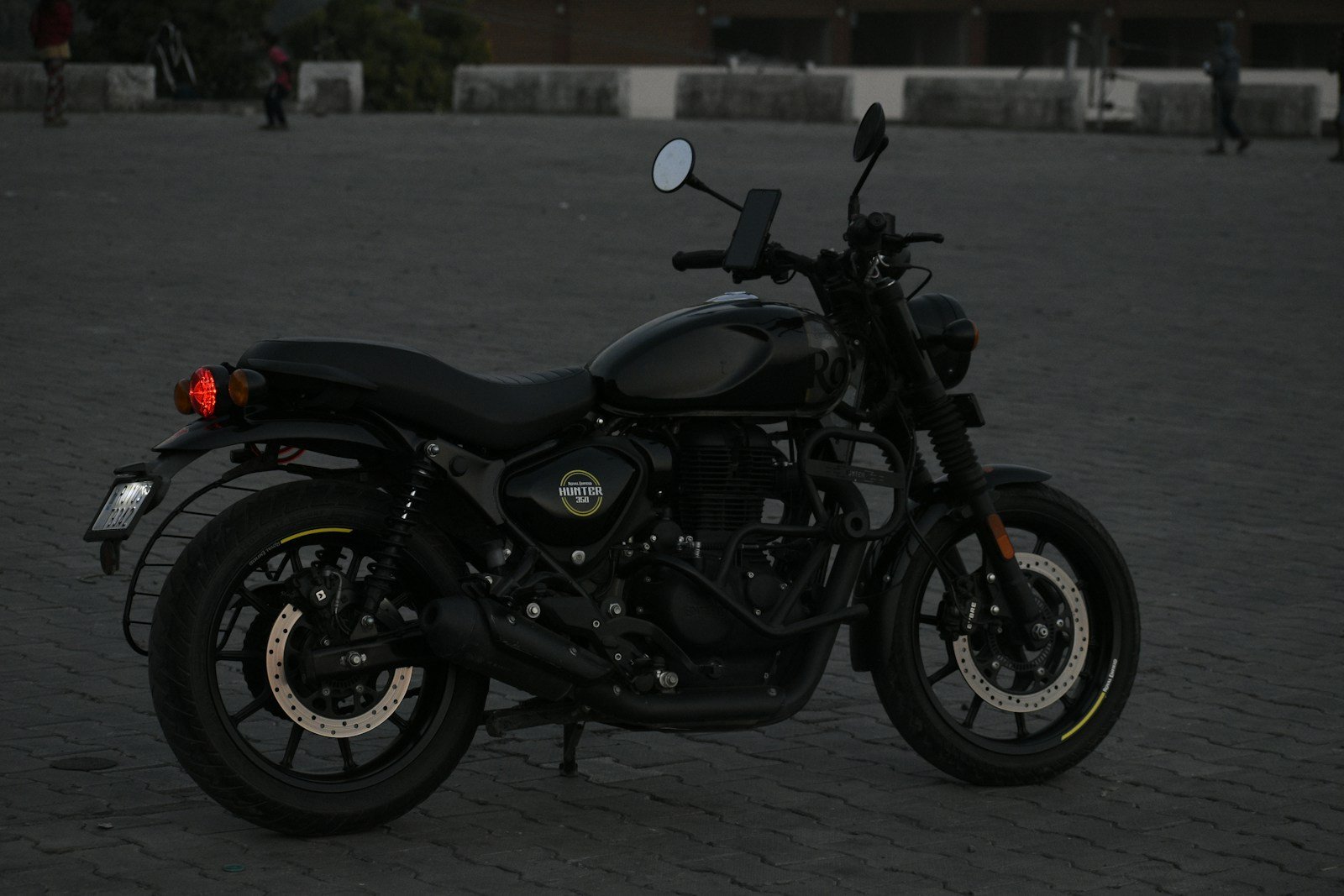 A black motorcycle is parked on a dark surface.